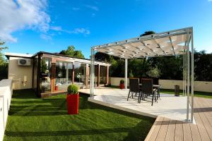 a deck with a pergola and a table and chairs at Feel Good Penthouse With Jacuzzi in Zadar