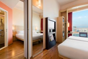 a hotel room with two beds and a window at Ibis Hong Kong Central & Sheung Wan in Hong Kong +37 photos