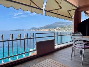 einen Balkon mit einem Tisch, Stühlen und Meerblick in der Unterkunft Una terrazza sul mare - Balzi Rossi in Ventimiglia