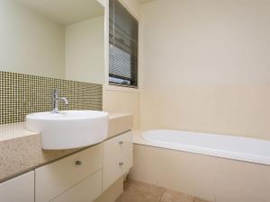 ein Badezimmer mit einem Waschbecken und einer Badewanne in der Unterkunft Rolling Waves No 2 in Merimbula
