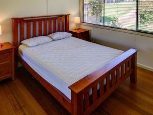 A bed or beds in a room at Henny's of Merimbula