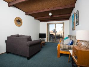 a living room with a couch and a chair at Fishermans Lodge in Merimbula