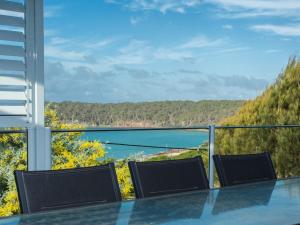 a table and chairs on a balcony with a view of the water at Seascape in Pambula Beach