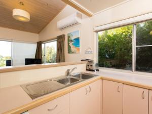 a kitchen with a sink and a window at Seascape in Pambula Beach