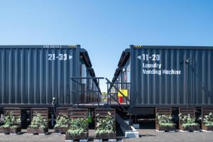 Due vagoni ferroviari con piante natalizie tra di loro di HOTEL R9 The Yard Koga a Koga