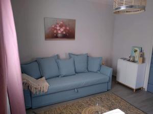 un sofá azul en una sala de estar con una pintura en Atelier Benjaminte, en Maillane