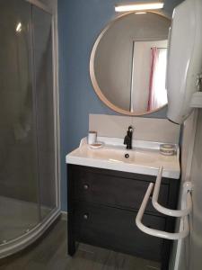 y baño con lavabo, espejo y ducha. en Atelier Benjaminte, en Maillane