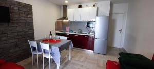 科米扎Apartments SUHO Komiza的配有桌椅和冰箱的厨房