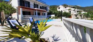 科米扎Apartments SUHO Komiza的一个带椅子和游泳池的别墅的阳台