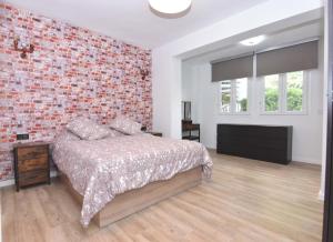 Un dormitorio con una cama y una pared de ladrillo. en El Parque Suite, en Benalmádena