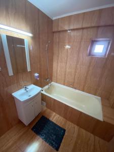 a bathroom with a tub and a sink and a mirror at Oriana in Constanţa
