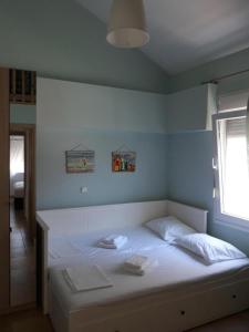 ein weißes Bett in einem Zimmer mit Fenster in der Unterkunft Τhe Diamond in Néa Péramos + 31 Fotos