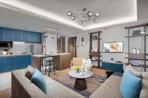 sala de estar y cocina con sofá y mesa en Citadines Yunlong Lake Xuzhou en Xuzhou