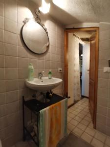 baño con lavabo y espejo en la pared en Casa MANETTA, en Calascio