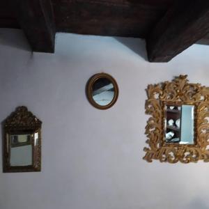 un miroir sur un mur blanc à côté d'une horloge dans l'établissement The Orangery Luxury Retreat. The Stacc, à Tursi