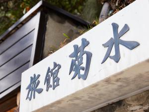 una señal para un edificio con escritura china en él en Kikusui Ryokan en Tamano