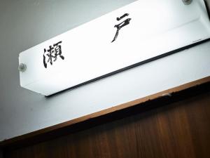 a sign on a wall with writing on it at Kikusui Ryokan in Tamano