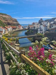 a town with a bridge over a river with flowers at Anchorlea in Staithes
