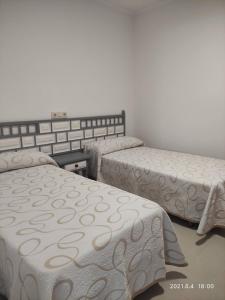 a room with three beds in a room at A Casiña do Miramar in A Lanzada