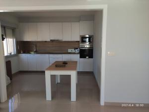 a kitchen with a table in the middle of it at A Casiña do Miramar in A Lanzada