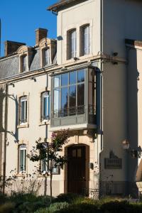 a building with a balcony on the front of it at Hôtel Saint Philibert in Tournus