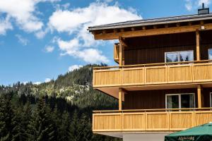 ein Gebäude mit einem Balkon mit einem Berg im Hintergrund in der Unterkunft Alpengasthof Hörnlepass in Riezlern