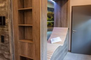 a room with a bed and a door with a balcony at StrandBerg's Ursprung: Spa & Kitchen in Braunlage