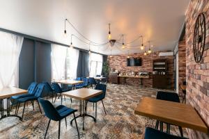 un restaurante con mesas y sillas y una pared de ladrillo en Hotel Blagodat', en Gelendzhik