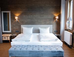 een slaapkamer met een groot bed met een blauwe poef bij StrandBerg's Ursprung: Spa & Kitchen in Braunlage