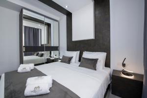 una camera da letto con un grande letto bianco e uno specchio di TWIN'S HOME LUXURY SUITES a Alikianós