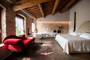 a bedroom with a bed and a chair and a tub at Magari Estates Boutique Hotel in Colognola ai Colli