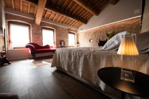 a bedroom with a bed and a table with a lamp at Magari Estates Boutique Hotel in Colognola ai Colli