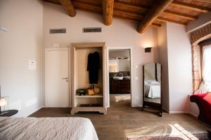 a bedroom with a bed and a mirror on the wall at Magari Estates Hotel in Colognola ai Colli