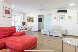 a living room with a red couch and a table at Beach Inn Deluxe Apartment in Alcudia