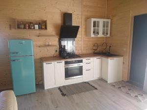 a kitchen with a blue refrigerator and white cabinets at Ranczo u Jarka in Jeżyce