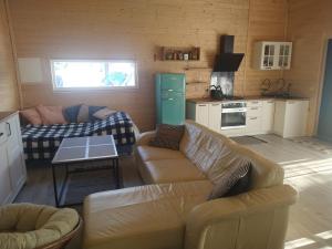 a living room with two couches and a kitchen at Ranczo u Jarka in Jeżyce