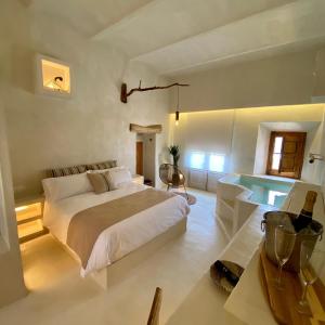 a white bedroom with a bed and a table at Can Massana in Pau