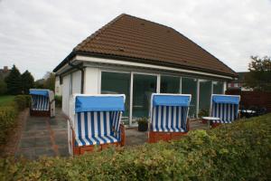 3 blaue und weiße Stühle auf einer Terrasse in der Unterkunft Ferienwohnungen im Hotel garni zur Post in Utersum