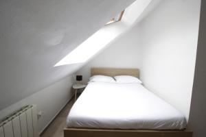 1 dormitorio con 1 cama blanca en el ático en Tramway 9 JAURES Cosy proche gare, en Le Mans
