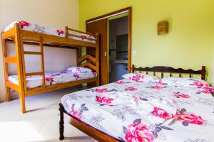 a bedroom with two bunk beds with pink flowers at Harmoni Hostel & Pousada in Abraão