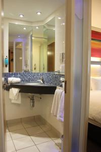 a bathroom with a shower, sink, and mirror at Holiday Inn Express Cardiff Airport, an IHG Hotel in Rhoose