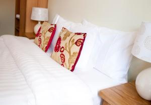 a white bed with four pillows on it at Kings Arms in Thirsk