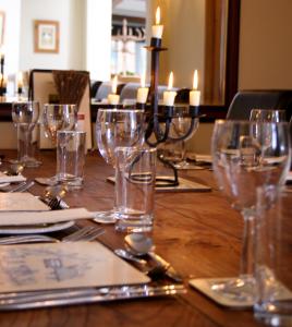 a wooden table with wine glasses and candles on it at Kings Arms in Thirsk