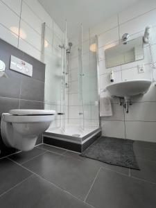 a bathroom with a shower and a toilet and a sink at MOTELO Bielefeld - Smart HOTEL in Bielefeld