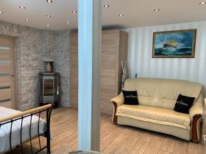 2 Aussicht auf ein Wohnzimmer mit einem Sofa und einer Treppe in der Unterkunft Apatamentas Nidos centre in Nida