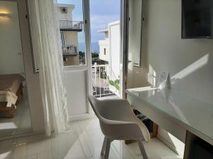 una scrivania bianca e una sedia in una stanza con finestra di B&B JOELE a Tropea