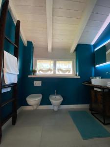 Baño azul con aseo y lavamanos en Apartment Gisa, en Colazza