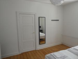 a bedroom with a door and a mirror on the wall at Lillegrund in Copenhagen