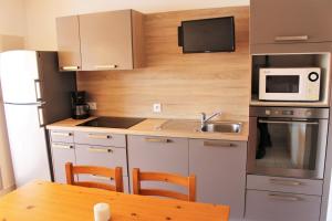 Una pequeña cocina con una mesa y un microondas. en Marinas et mer 25, en Saint-Cyprien