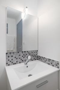 lavabo blanco con espejo grande en L'Oasis, en Palavas-les-Flots